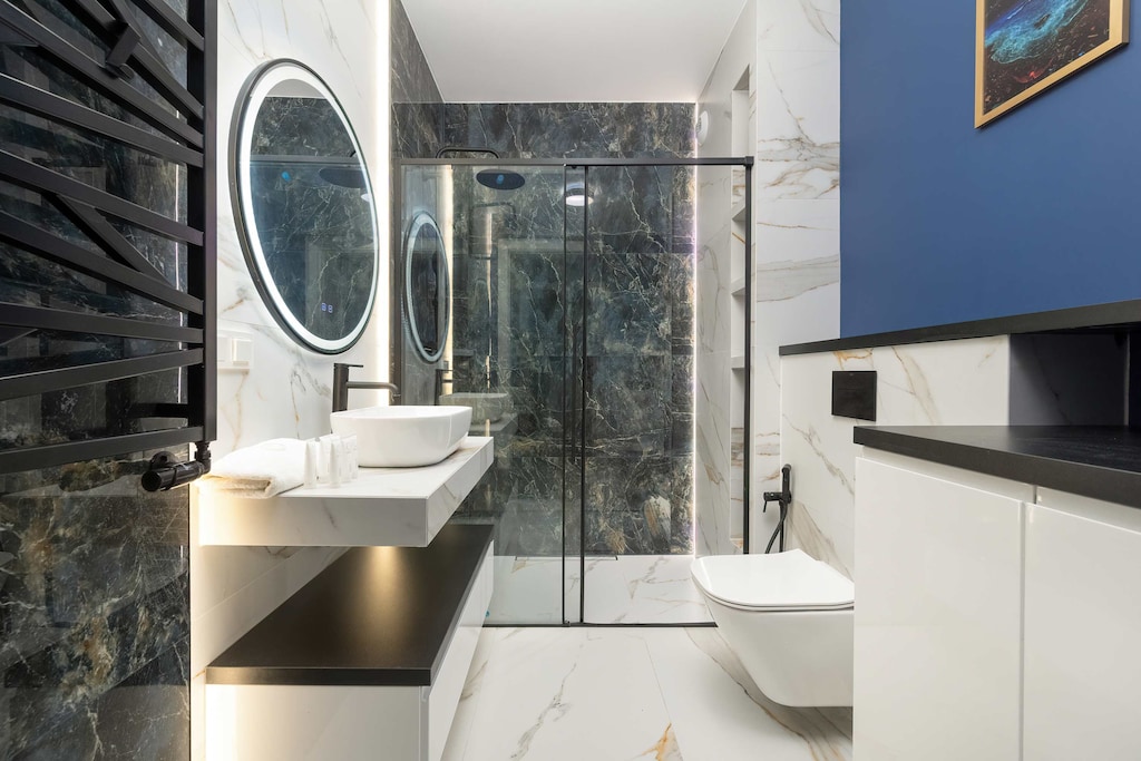 The stylish bathroom with a glass shower and elegant details ensures comfort during daily rituals.