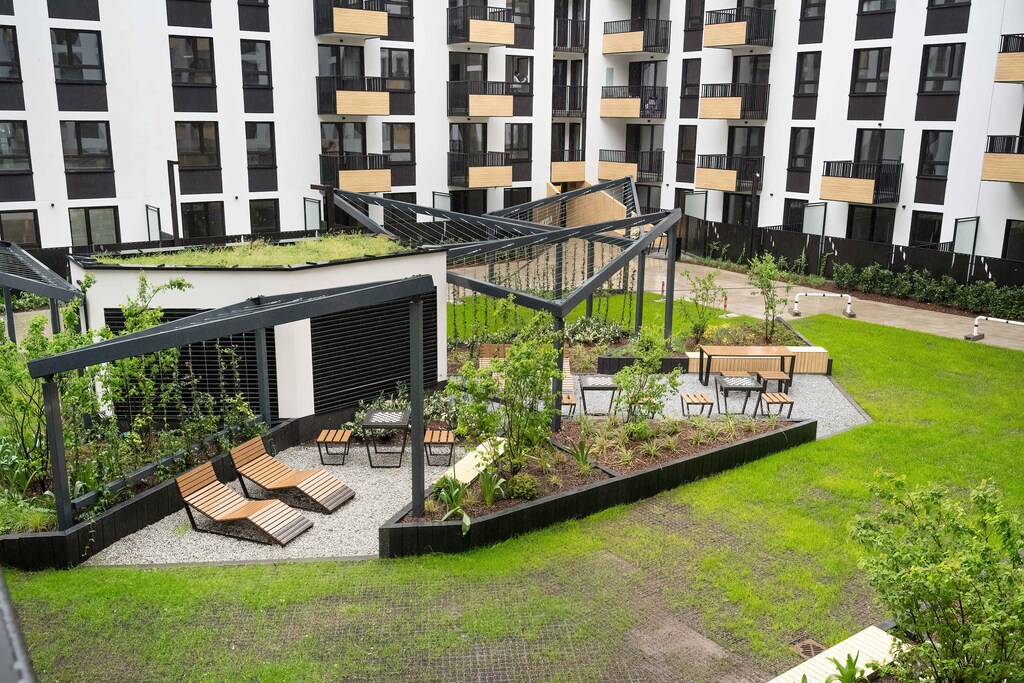 The green courtyard with a pergola and seating area lets you enjoy peaceful moments outdoors.