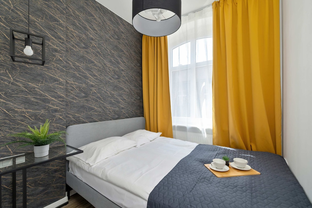 A peaceful bedroom with a comfortable double bed, perfect for restful nights. Bright curtains and minimalist decor create a calm atmosphere.