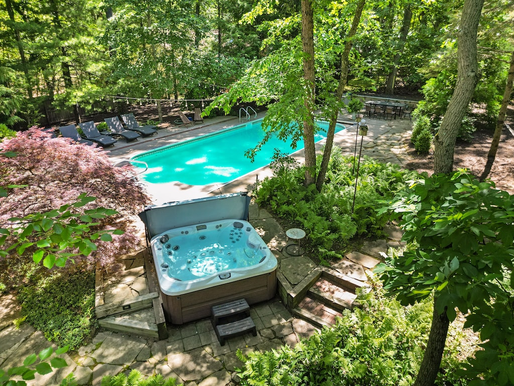 Lounge poolside surrounded by trees and sunshine.