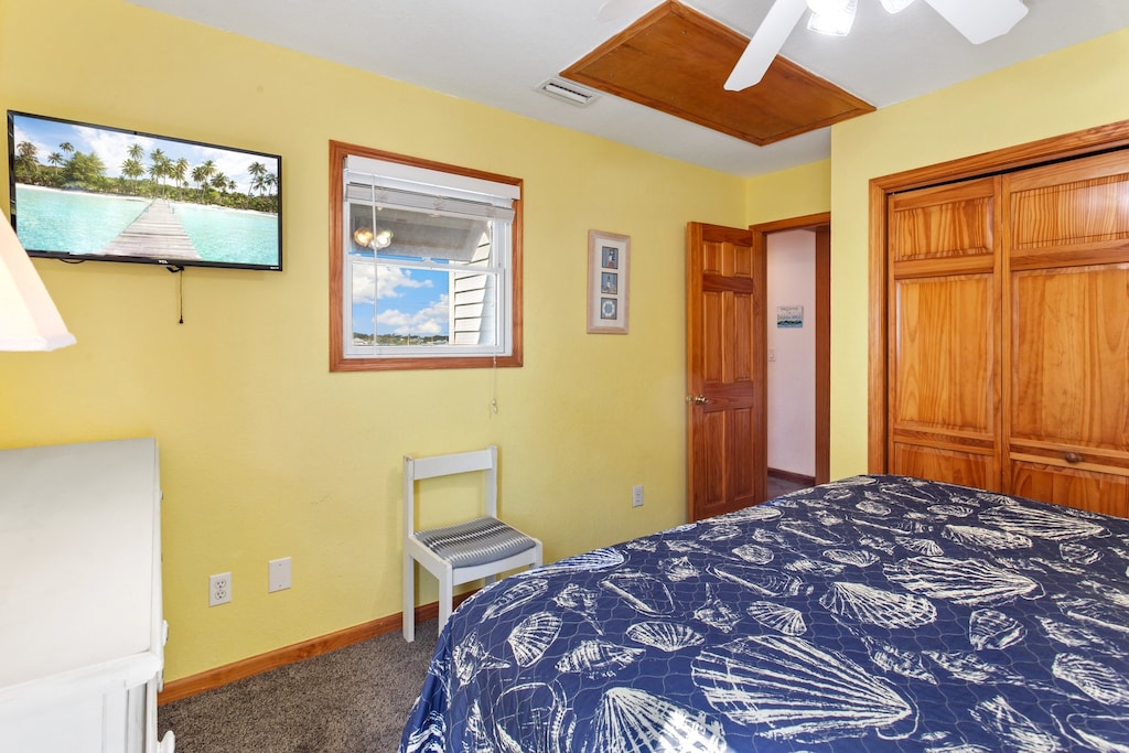 Unwind in the King Bedroom with an additional Flat Screen TV and hallway access to the Full Hallway Bathroom nearby.