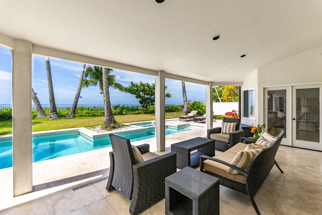 Unwind poolside beneath a shaded lanai—perfect for morning coffee or evening cocktails with the sound of ocean waves nearby.