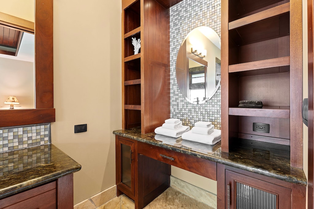 Thoughtfully designed vanity area with custom wood cabinetry and ample storage for your essentials.