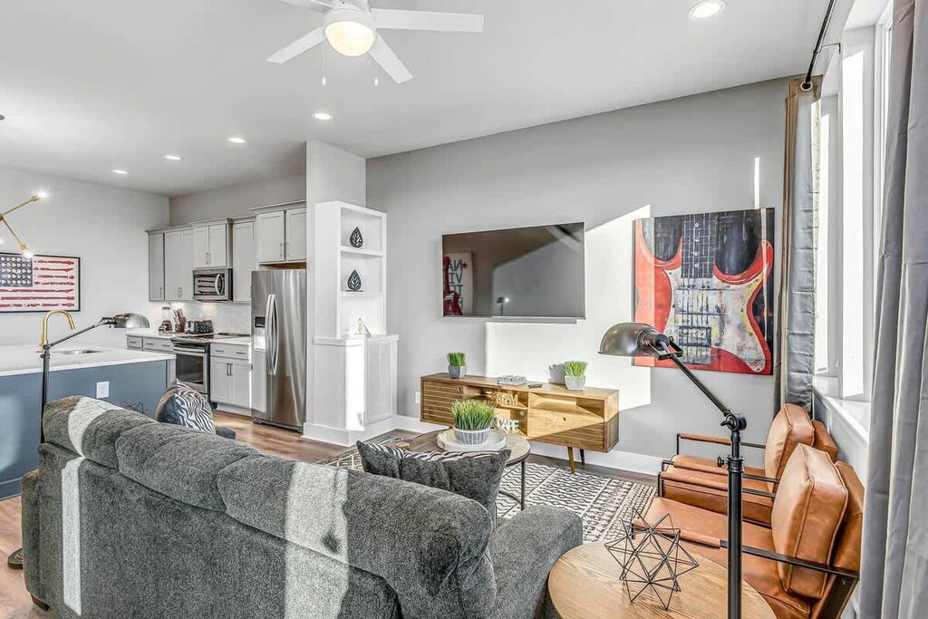Well-lit living area with a mounted TV and a painted guitar frame!