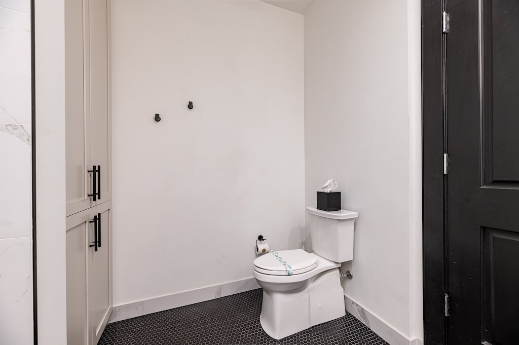 The primary bathroom offers sleek finishes, a soaking tub with Smart TV, walk-in shower, and plush towels. Spacious and private, it adds a luxurious touch to your suite—perfect for unwinding after a day in Downtown New Orleans.