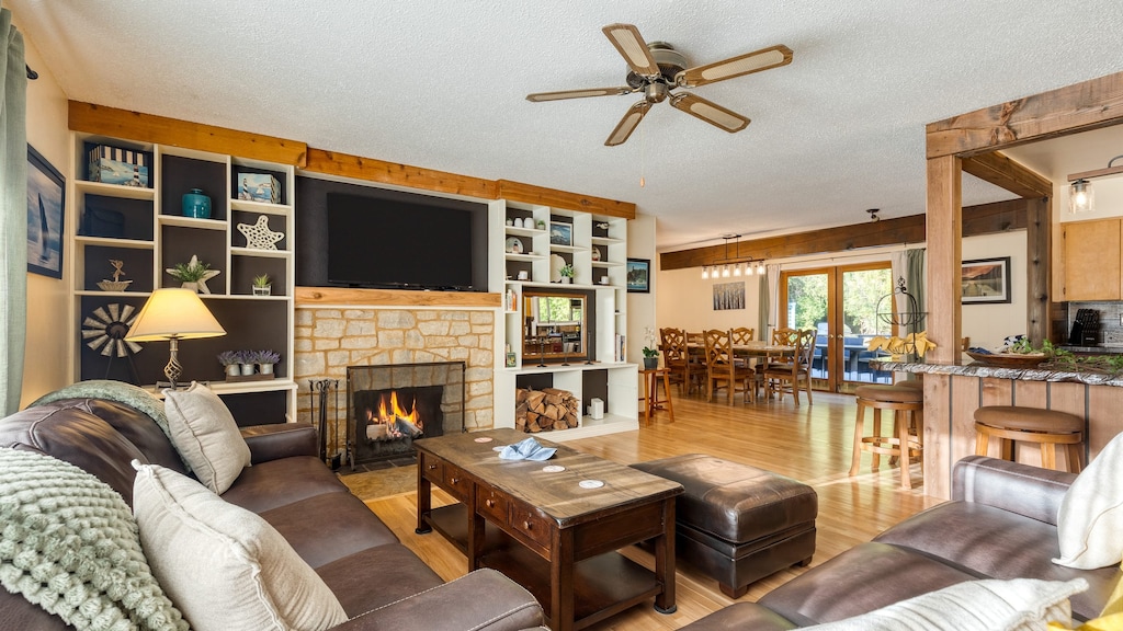 Relax in the cozy living room with a fireplace, flat-screen TV, and custom shelving.