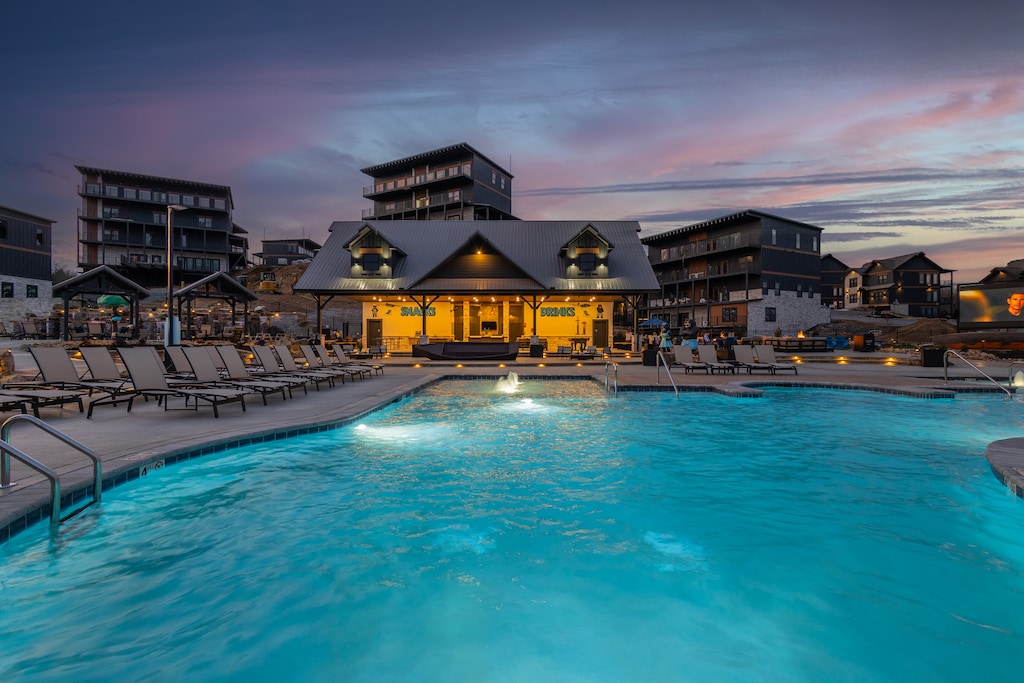 A daytime shot of the resort’s main swimming pool with luxury cabanas, lounge chairs, and modern architecture in the background.