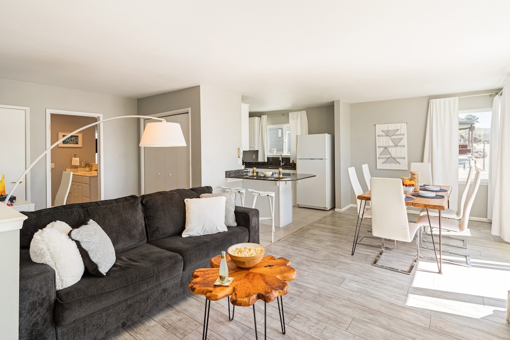 Bright and stylish living room with cozy seating and dining area. (Cayucan Bungalow 224)