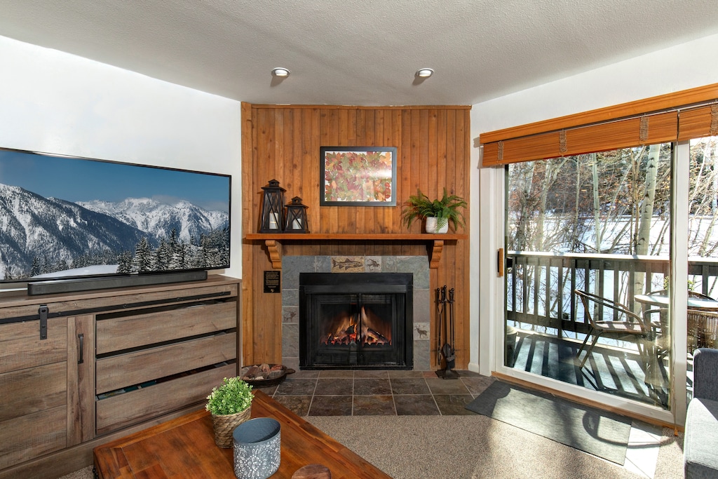 The living room has comfortable couches, gas burning fireplace and views of the aspen grove.