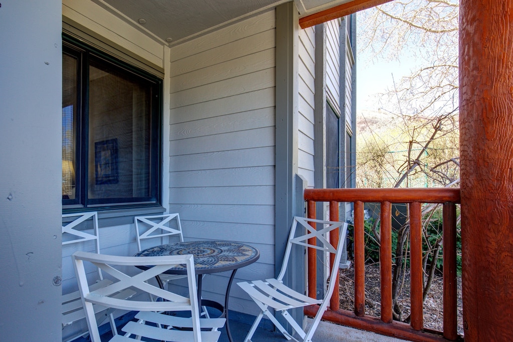 Snow Flower 12's deck with wooden railing, small round table and 4 chairs.