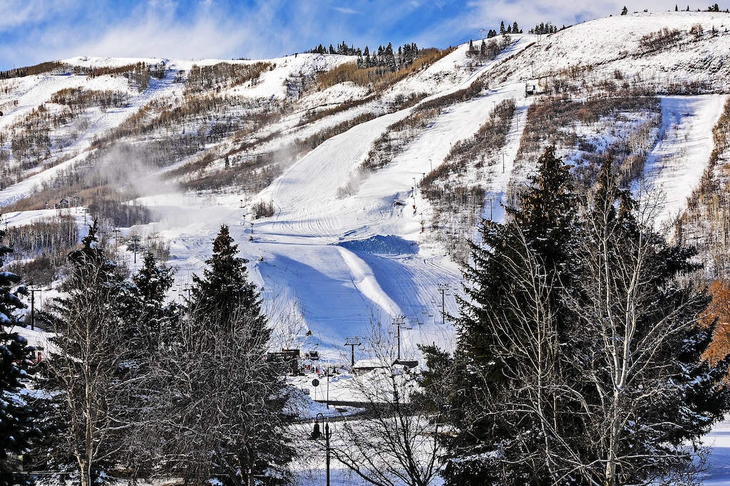 Snow-covered ski slopes and chairlifts create a winter wonderland in the surrounding mountain area.