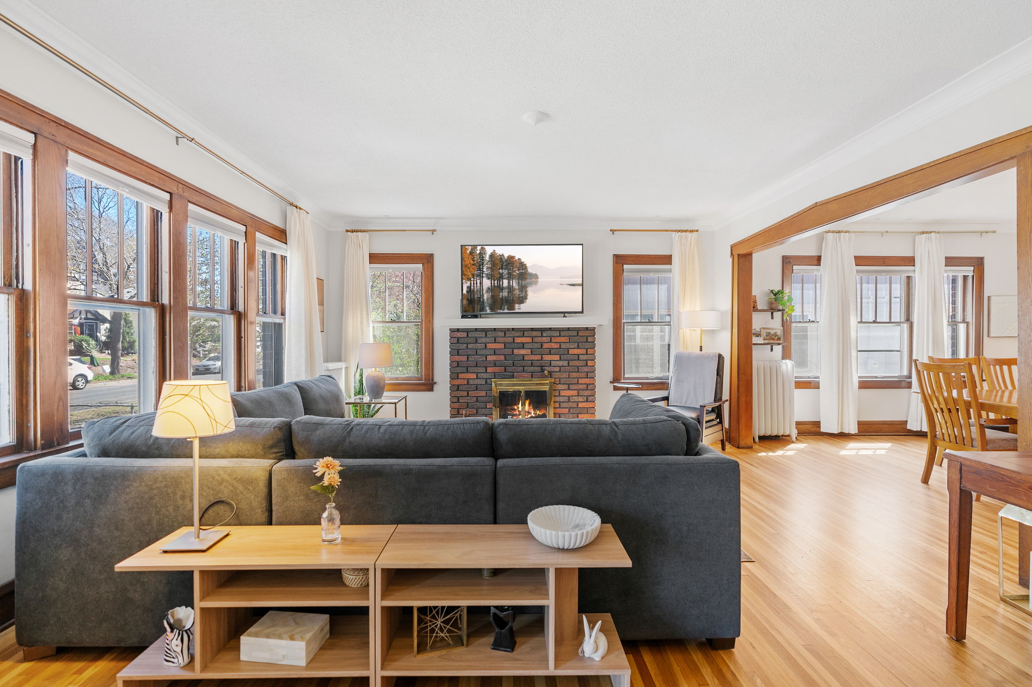 Curl up on your cozy sectional by the warm brick fireplace in this bright, open living space with gleaming hardwood floors.