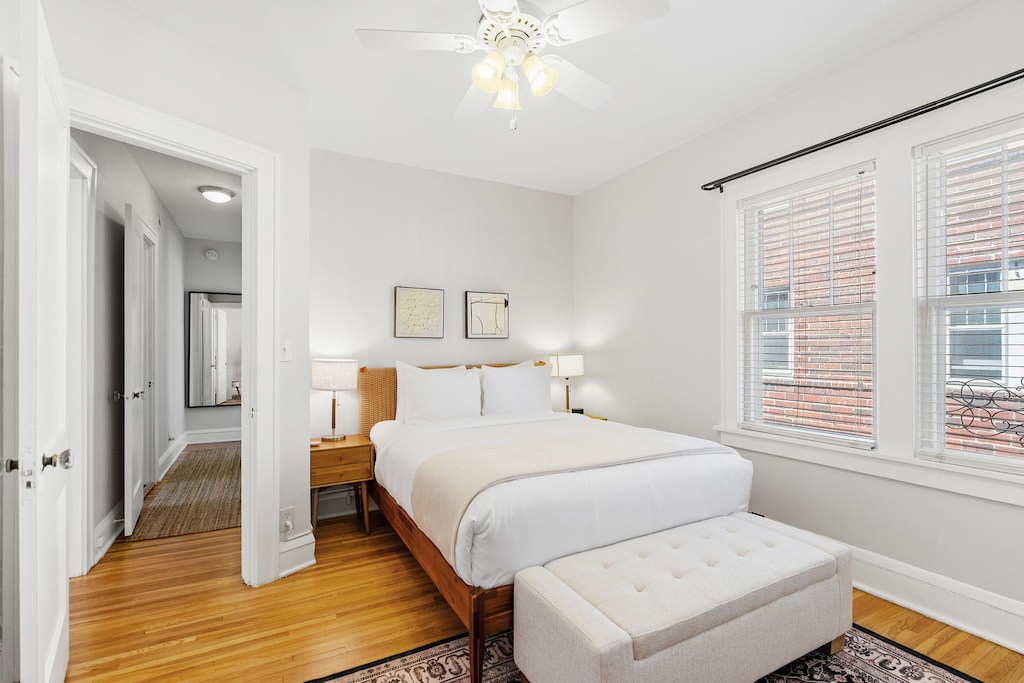 Sink into crisp white linens and warm wood tones in your peaceful retreat, where morning light streams through large windows.