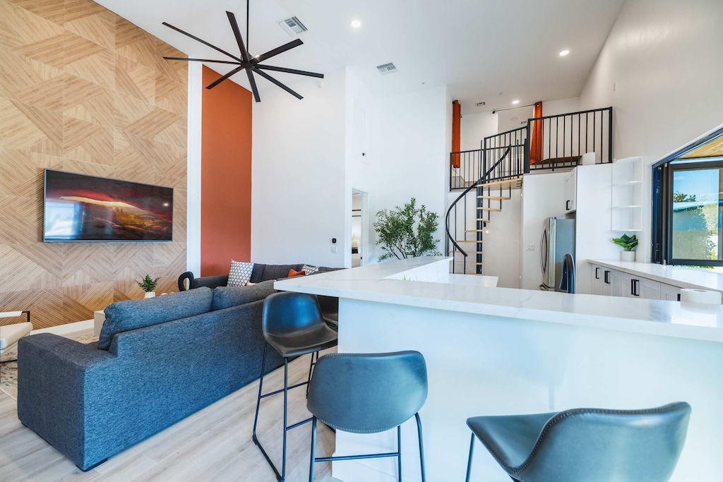 High ceilings and blue bar stools create a space that feels open and connected