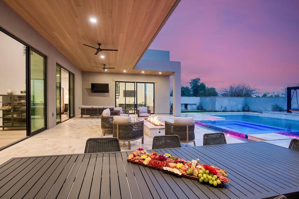 Covered patio with wood ceiling, outdoor seating, and stunning purple sunset views