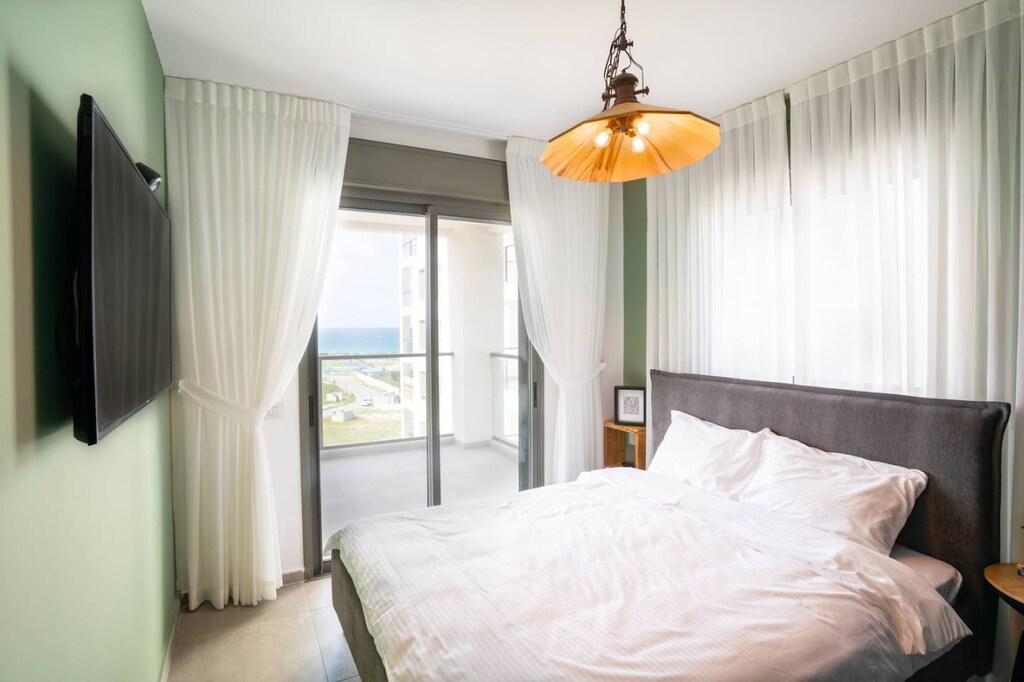 Bedroom 2 with hanging television and way to balcony