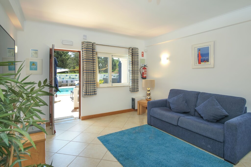 Open-plan lounge with flat-screen TV, kitchen, and dining area