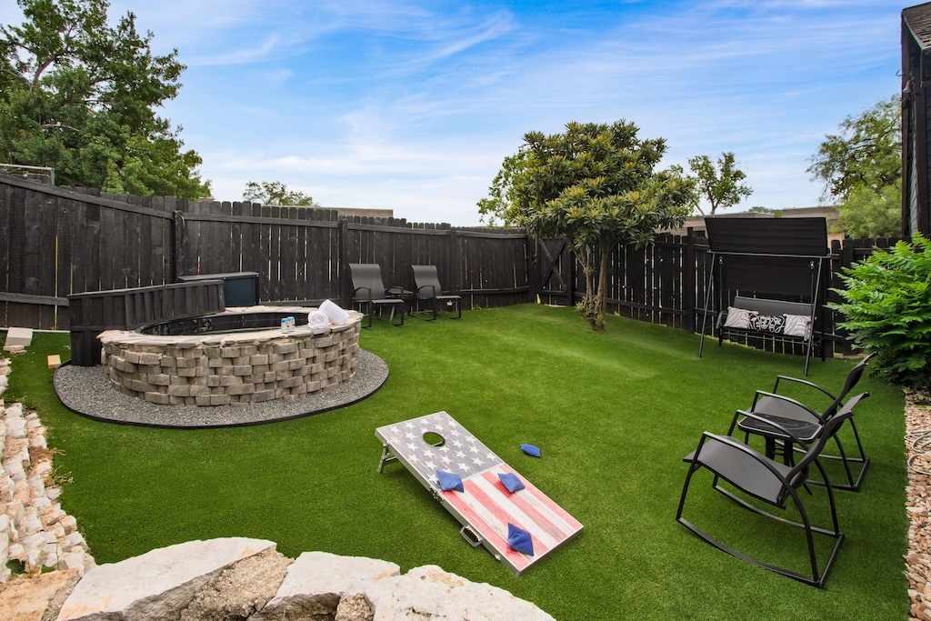 Shared fully fenced backyard with hot tub, al fresco dining, and cornhole.