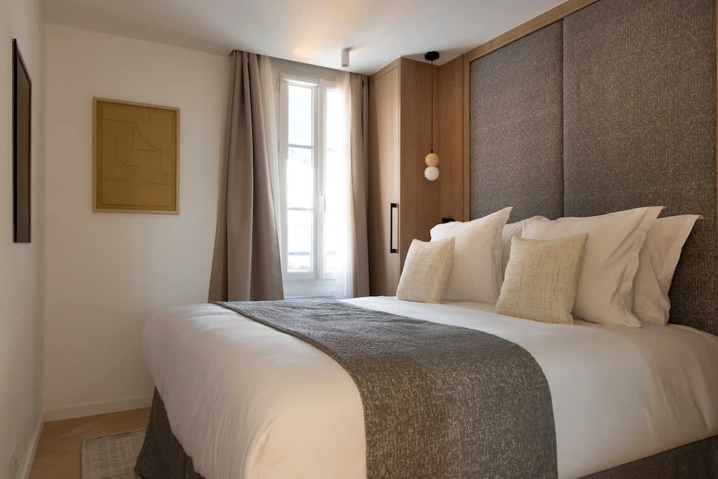 Une première chambre parée d’un lit Queen size, d'une penderie et d'une TV.