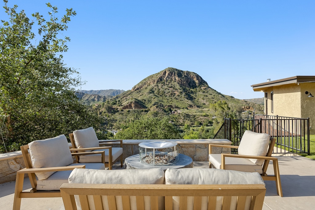 Lounge-ready outdoor living with fire pit and views of the hills.