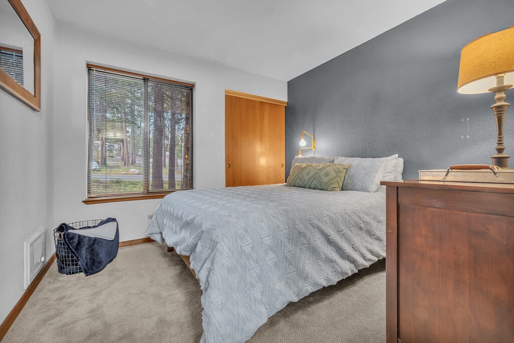 Bedroom with Queen size bed and ample storage in dresser drawers and closet for guest storage