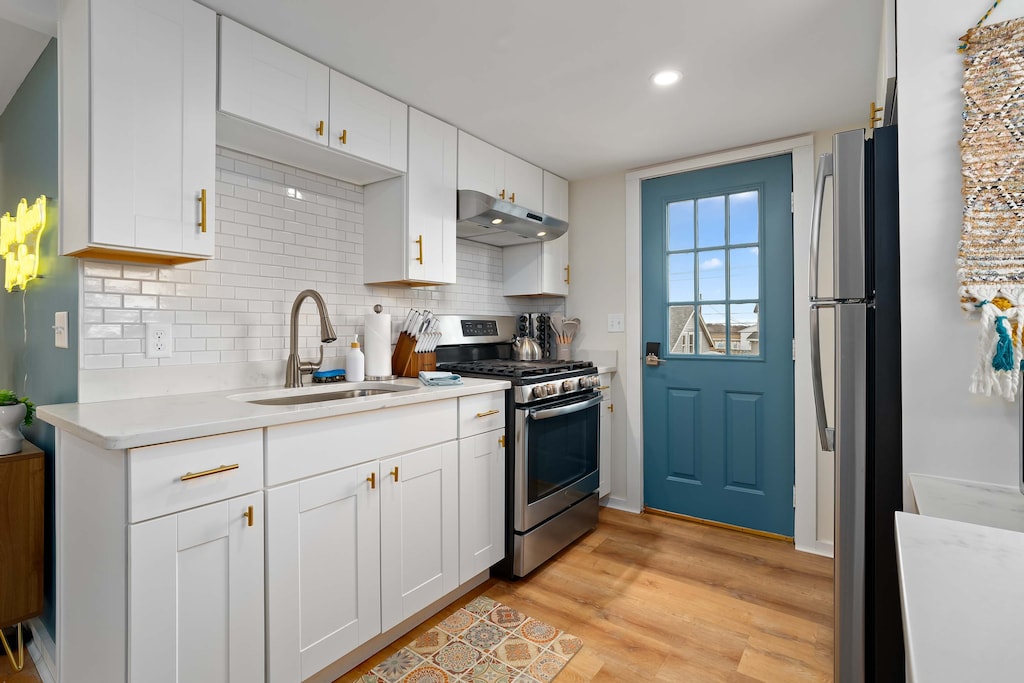 Open, living room, kitchen & dining room with "here comes the sun" neon light sign, flat screen smart TV & sleeper sofa. Private front covered deck with seating, back private deck with picnic table, yoga mats, dining table for 6 pp &  island for 2pp