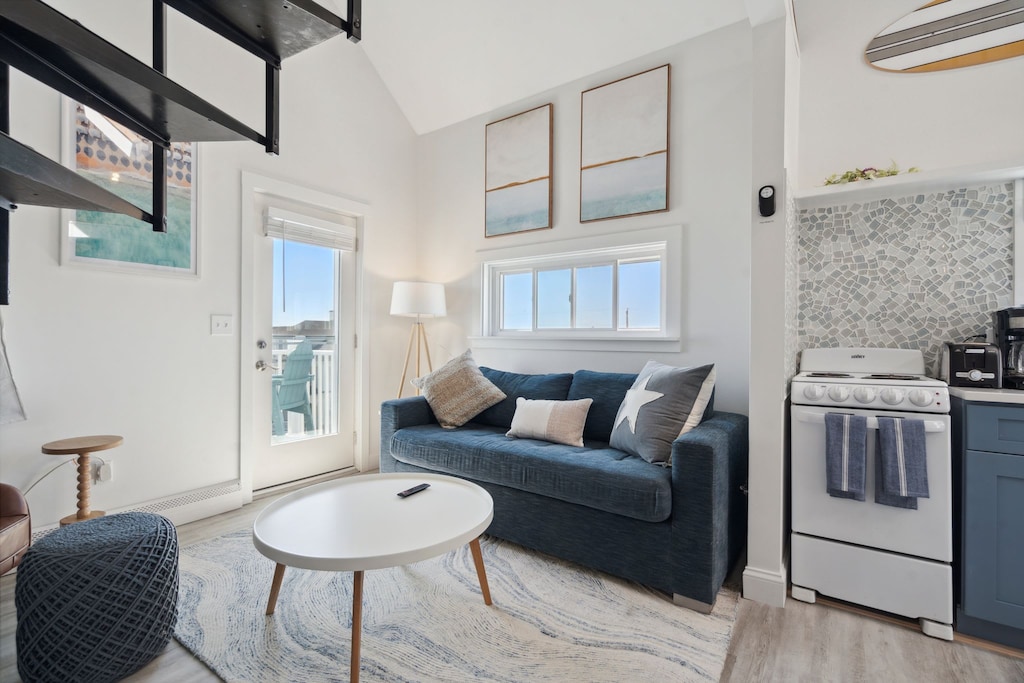 Living room with comfy couch, smart TV, and access to the private balcony