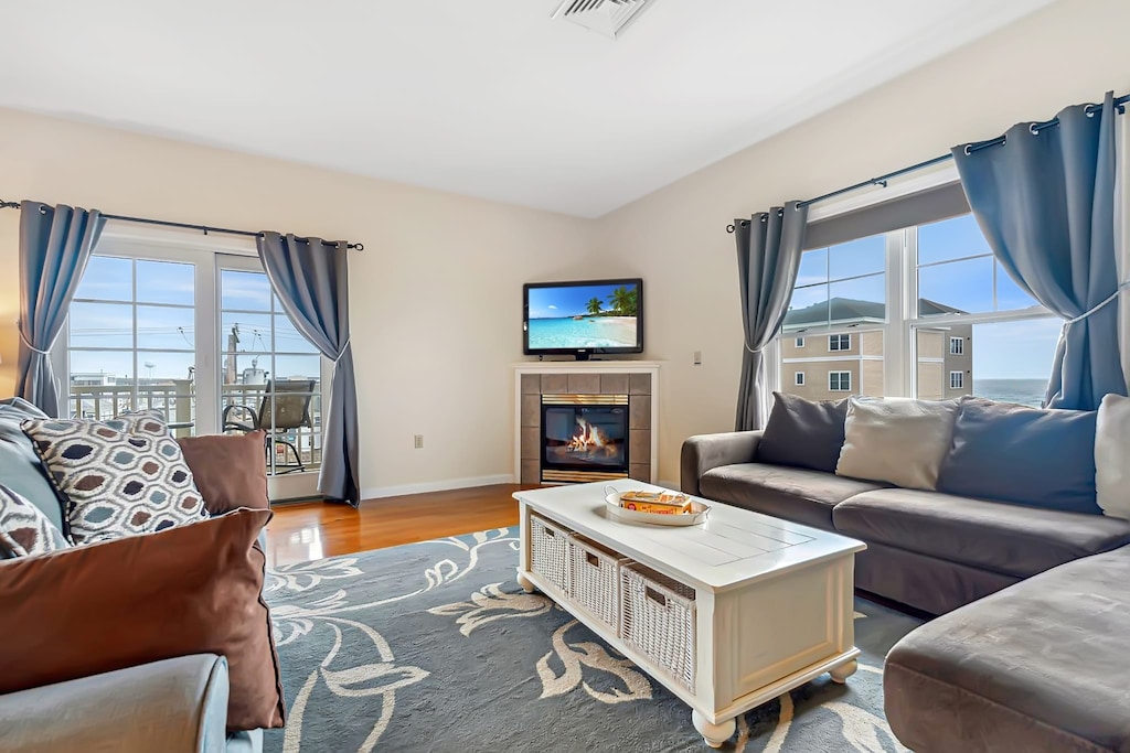 Living room with ocean views featuring both a sectional and pull-out couch, and access to the private balcony!