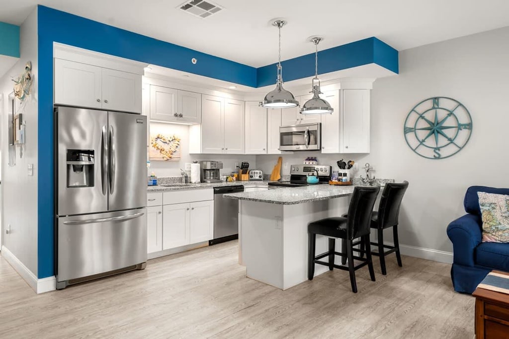 Open living room & kitchen, with mounted smart TV, Dining table, strong WiFi, sleeper sofa and fully-equipped kitchen