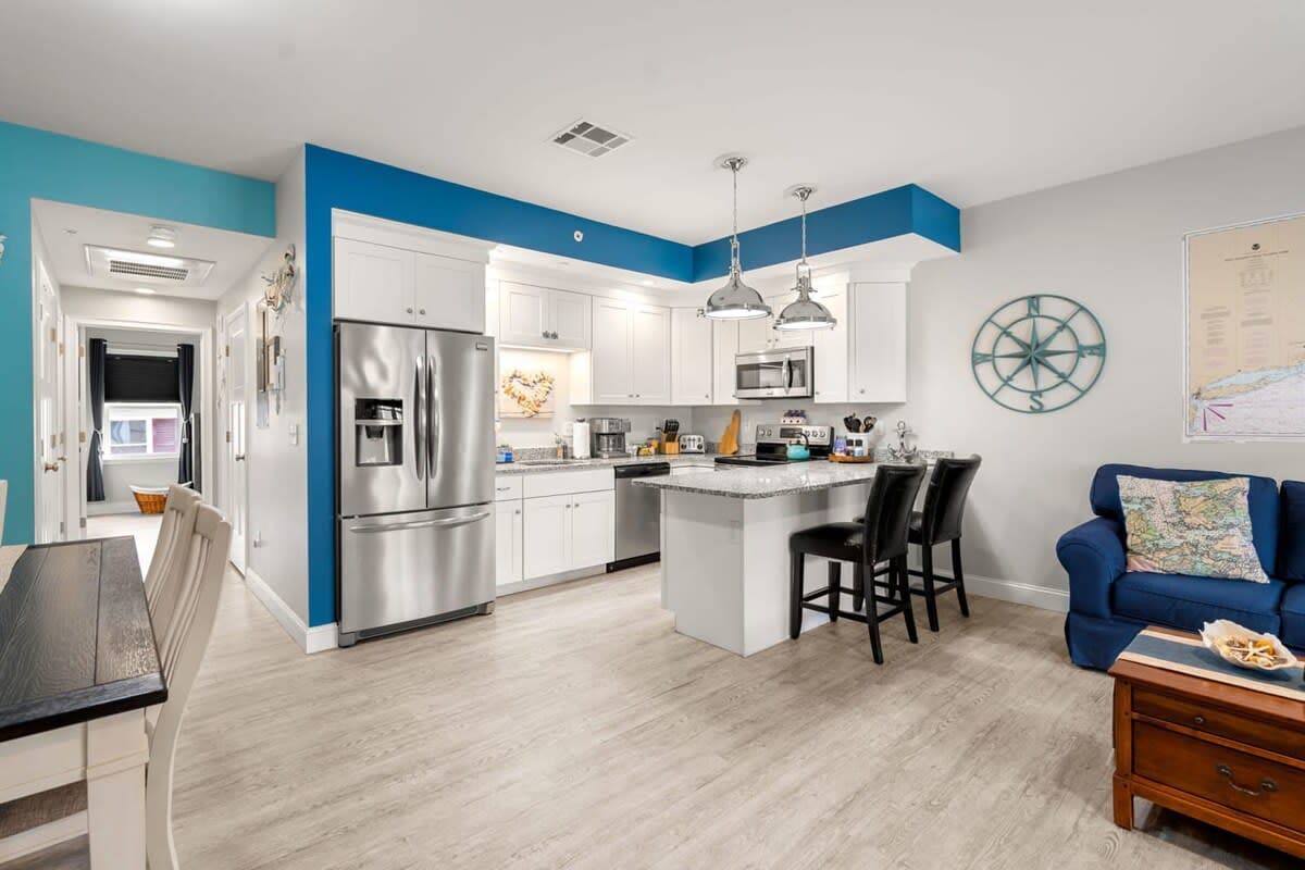 Open living room & kitchen, with mounted smart TV, Dining table, strong WiFi, sleeper sofa and fully-equipped kitchen