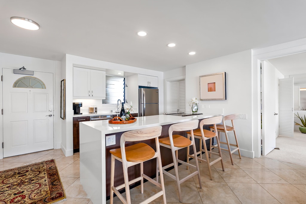 Gather around the kitchen island for coffee, cocktails, or shared meals in a breezy, casual space that brings everyone together after days on the beach.