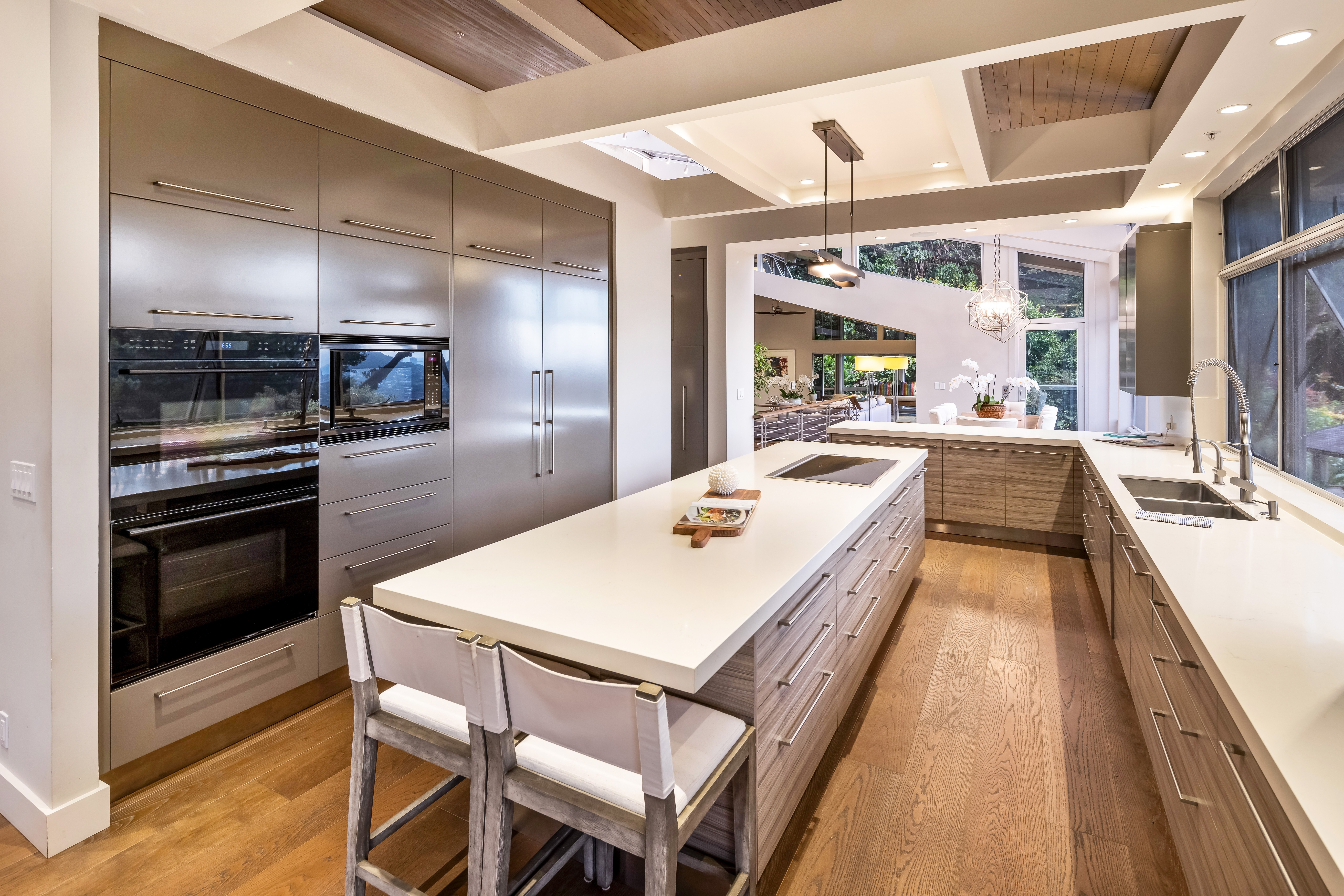 Chef’s kitchen with oversized island, high-end appliances, and panoramic garden views.