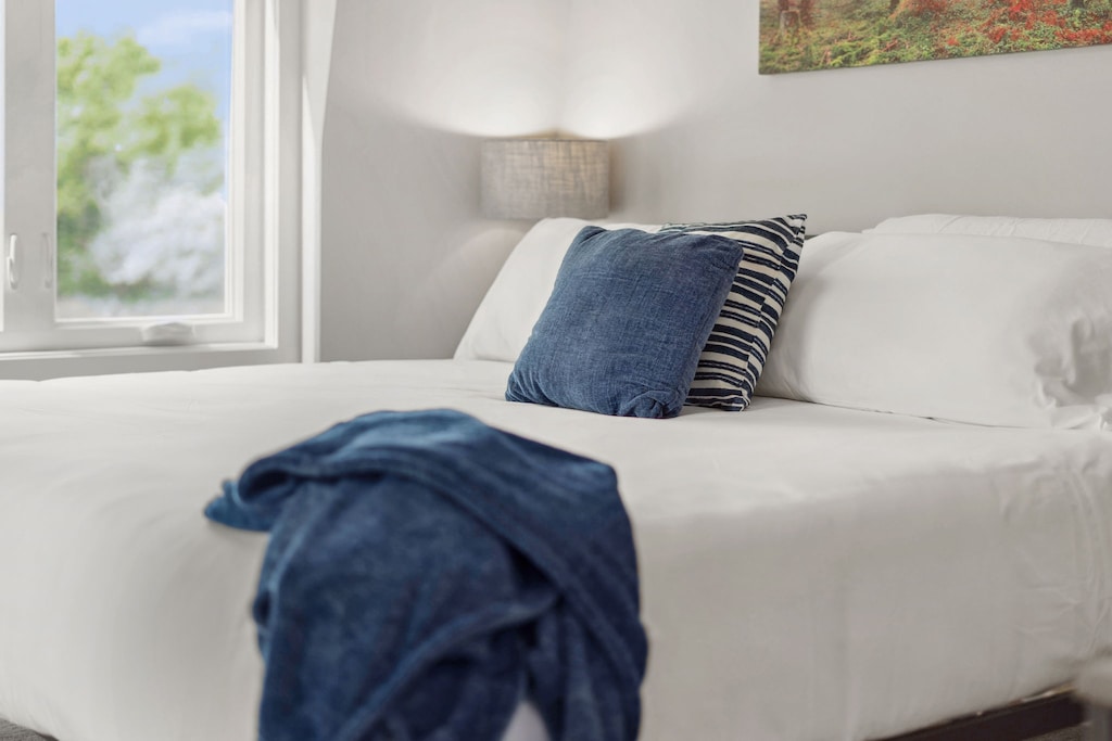 Sink into this comfortable bed with soft navy accents and wake up to gentle morning light streaming through your window.