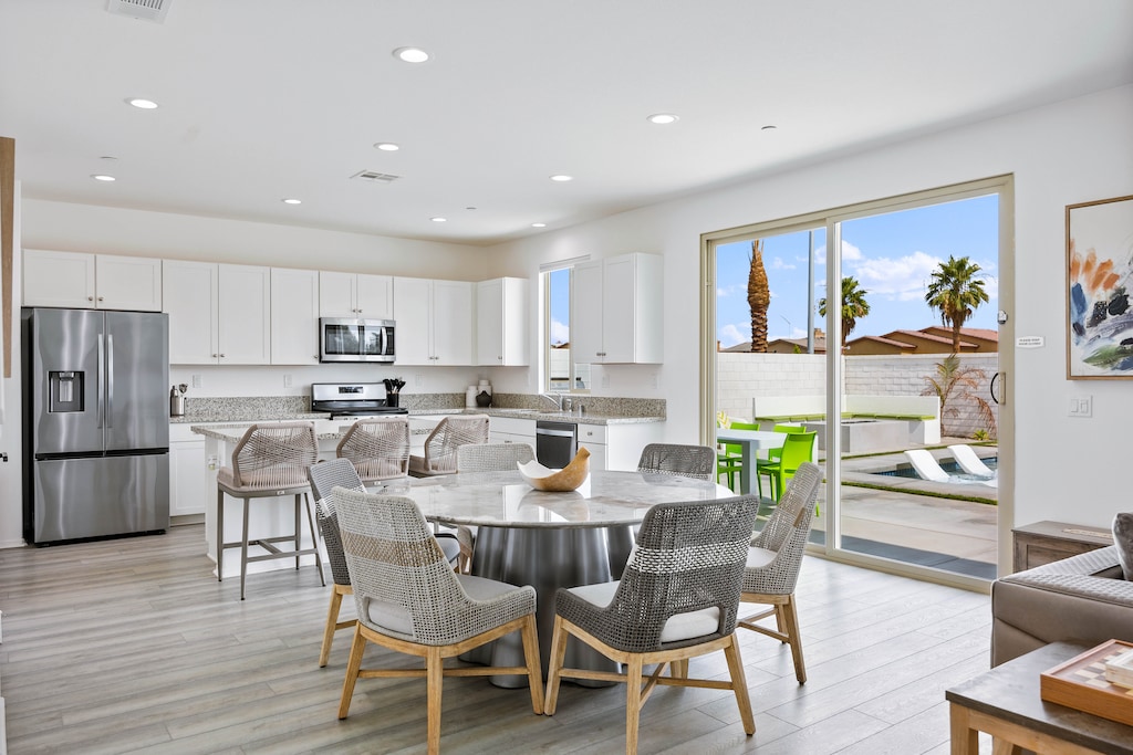 Open kitchen and dining area with glass doors to the patio makes hosting and entertaining effortless every single day.