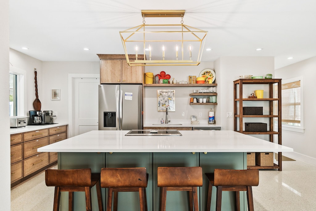 Your stylish kitchen awaits with gleaming countertops and warm wood accents. The spacious island beckons you to gather for morning coffee or evening conversations, while abundant natural light creates the perfect atmosphere for cooking memorable meals.