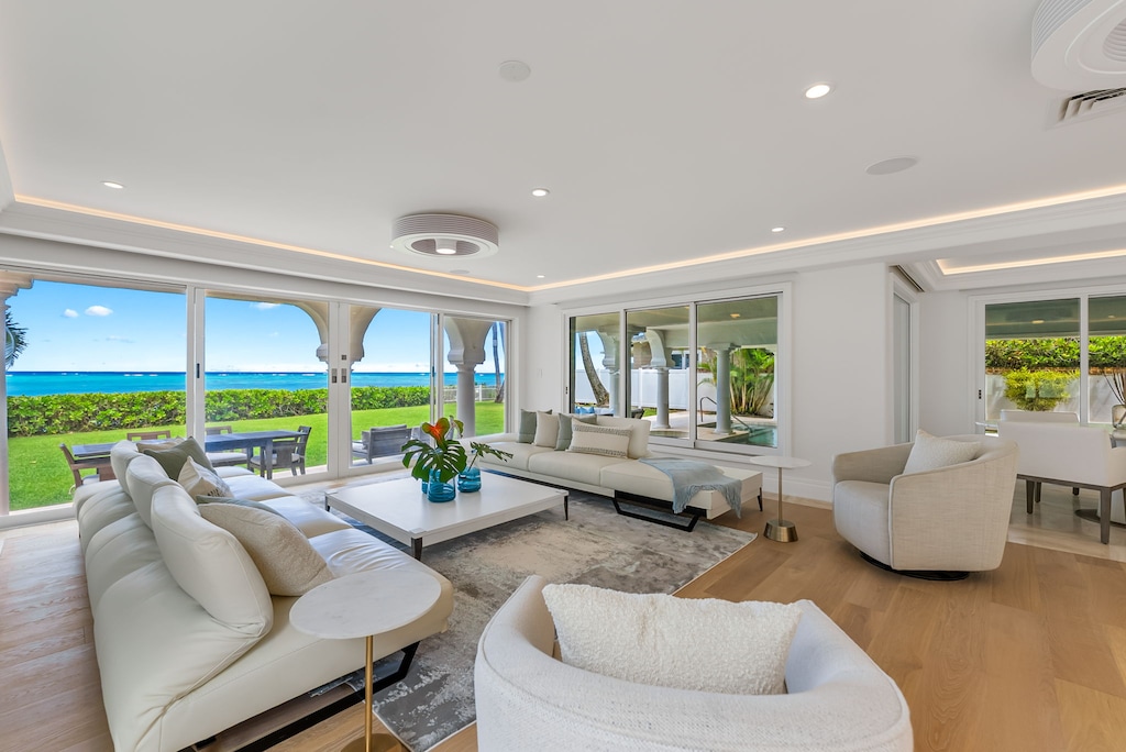 Bright and breezy living room with plush seating and panoramic beach views.