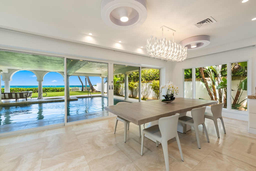 Gather indoors or out—elegant dining space framed by sliding glass doors and garden views.