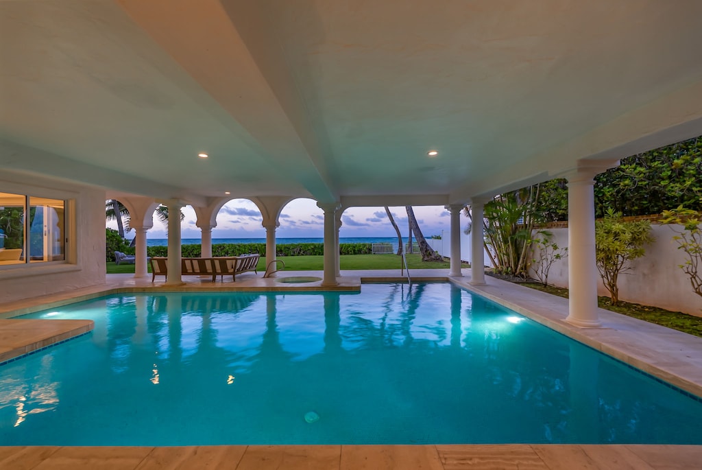 Twilight swim beneath vaulted arches in the covered ocean-view pool.