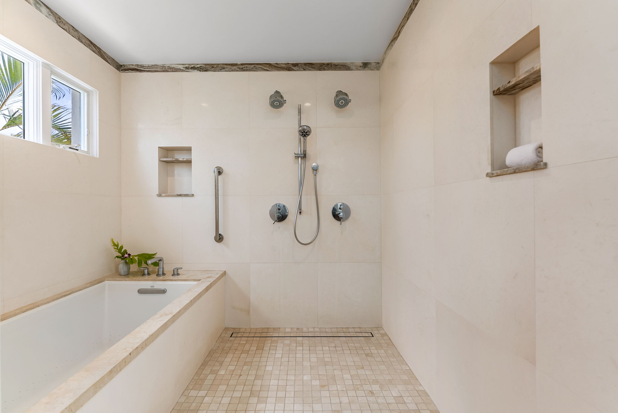 Walk-in shower with multiple showerheads and a built-in bench.