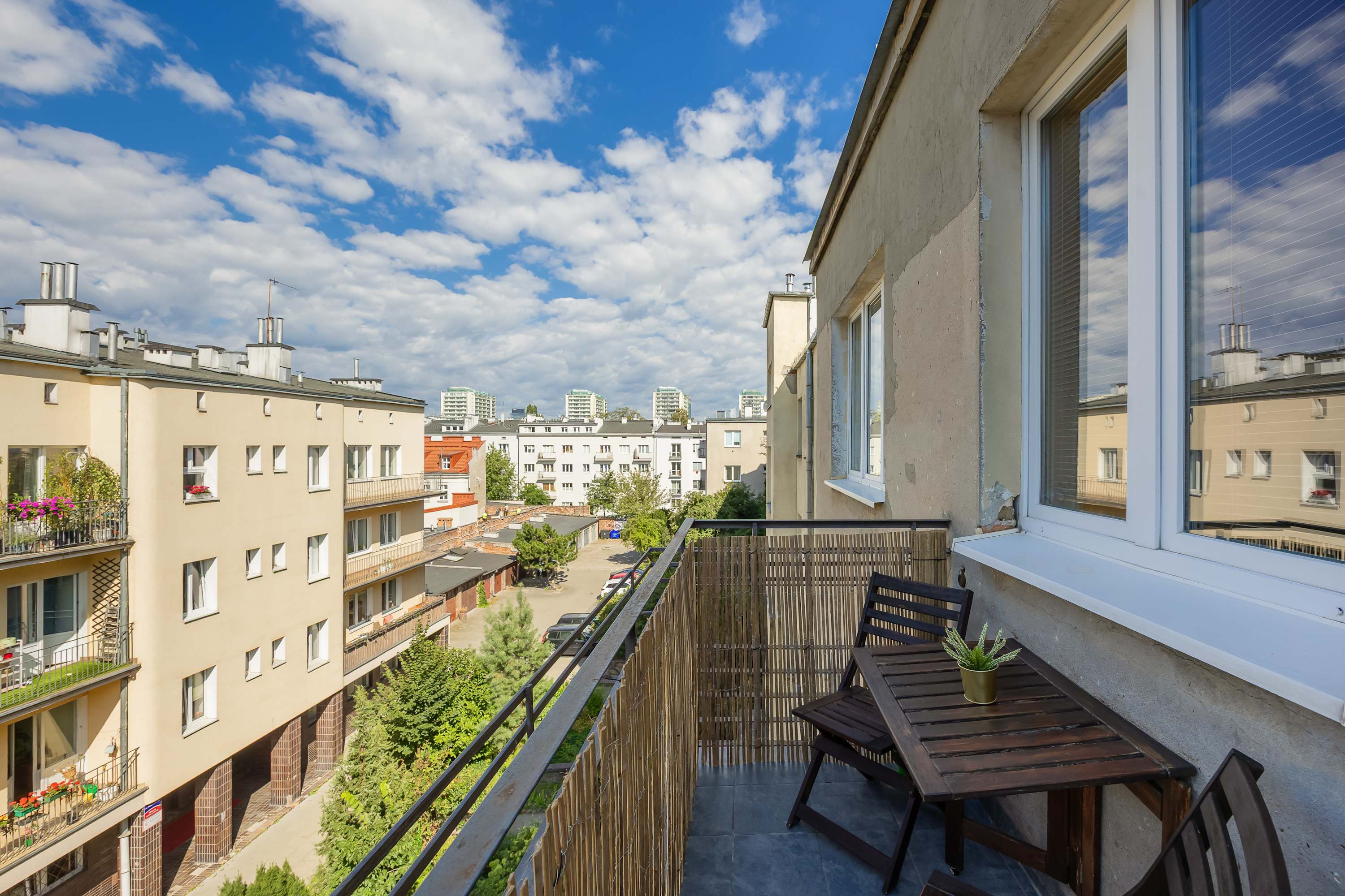 The furnished balcony with a view of the neighborhood is perfect for enjoying your morning coffee outdoors.