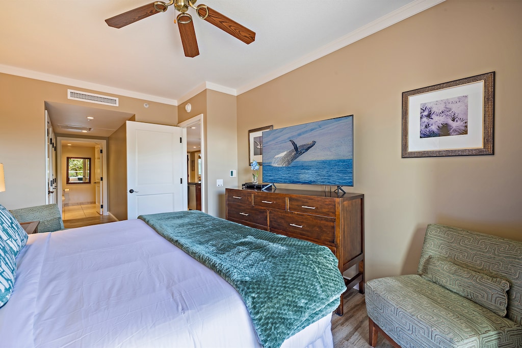 Spacious guest suite in Honua Kai Konea 230/232 with a flat-screen TV, dresser, and ceiling fan
