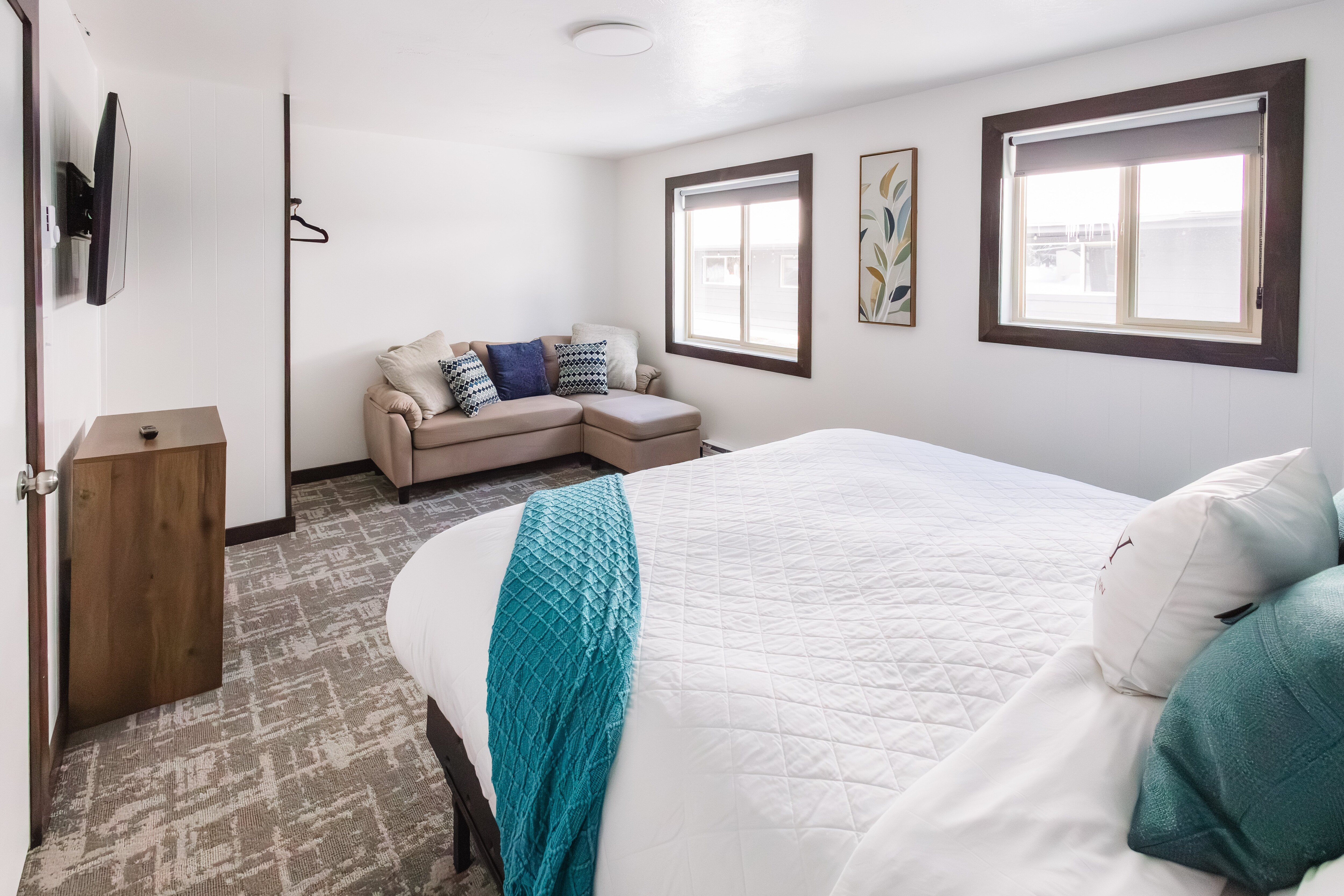 Guest room #1 with king size bed, small couch and flat screen TV