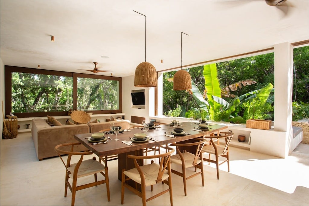 Spacious dining area connected to the living room. Designed in natural tones with large windows that connect to the exterior.