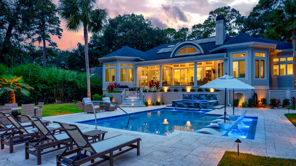 Luxurious Private Backyard with Pool, Ample Seating, and Screened in Porch at Sunset