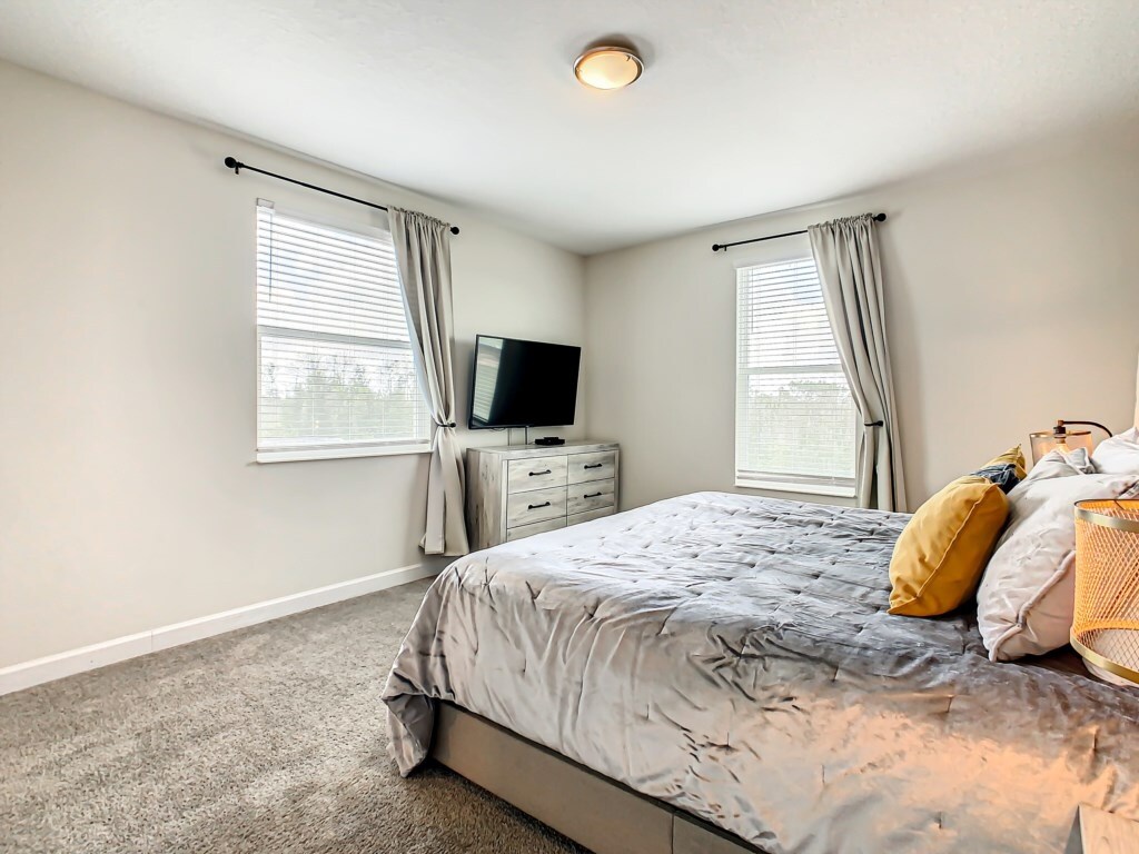 Cozy and stylish bedroom with a TV and dresser for added convenience.