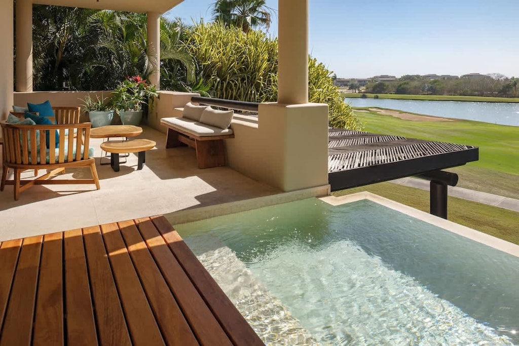 A terrace with a living area, pool, and views.
