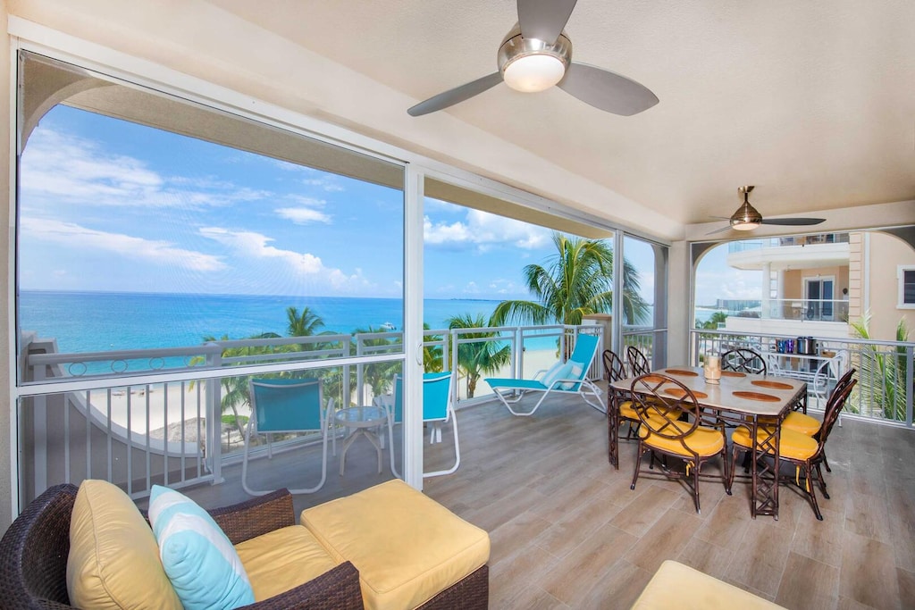 Furnished corner unit balcony with lounge seating and dining table.