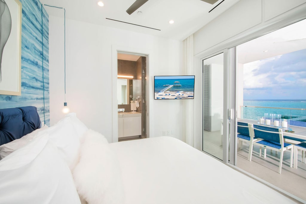 Primary Suite with king bed, television, and walk-out access to the balcony.