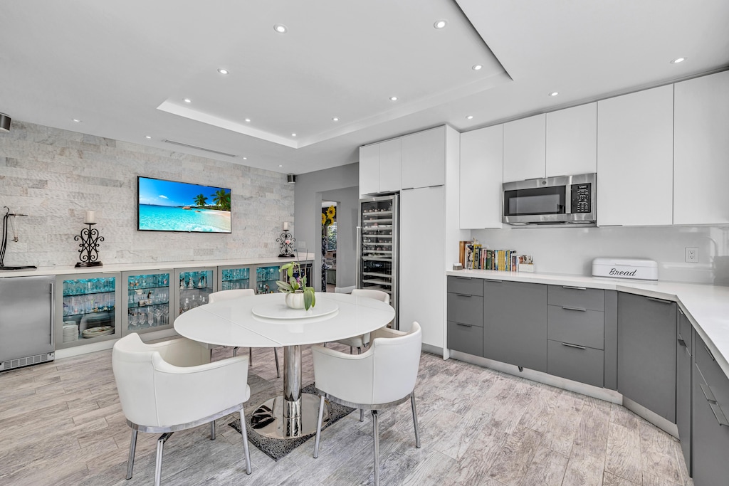Kitchen Dining Area | A cozy kitchen dining nook with seating for 4, beverage fridges, wine bar, and a Smart TV for casual meals.