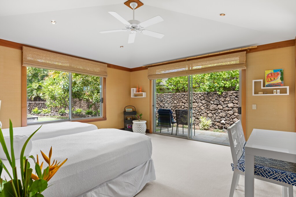 Third guest bedroom with twin beds (convertible to king) and private access to lush outdoor space.
